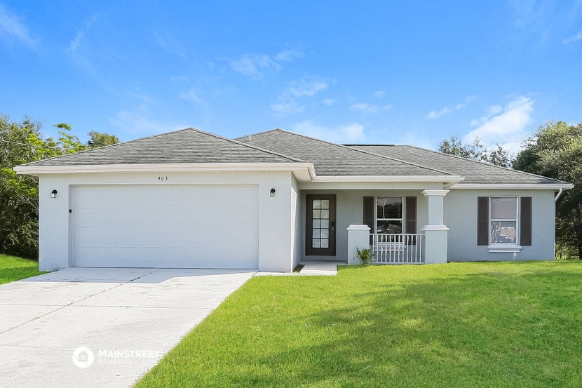a white house with a lawn and a garage door