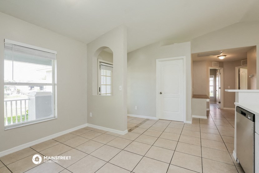 an empty kitchen and living room with a large window