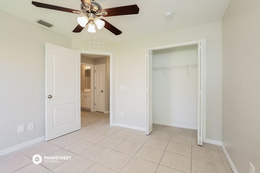 a bedroom with a ceiling fan and a closet