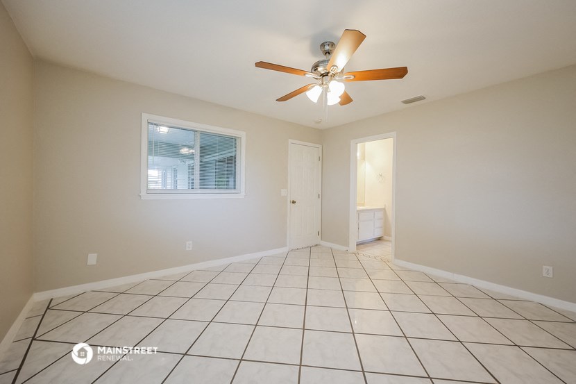 the living room of an empty house with a ceiling fan