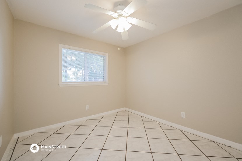 the living room of an empty house with a ceiling fan