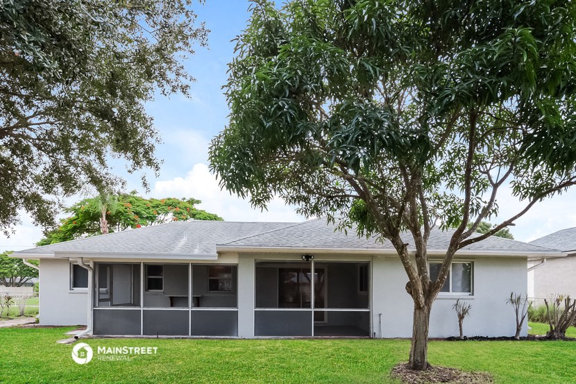 a white house with a tree in front of it