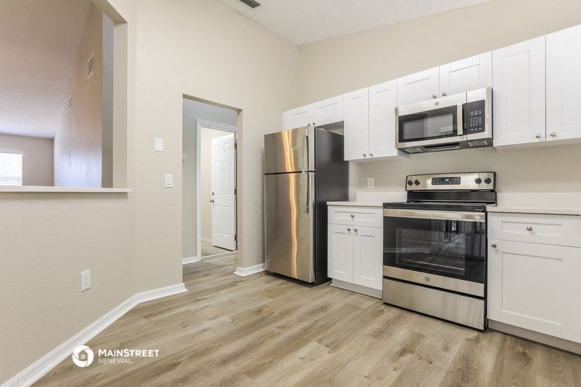 a white kitchen with stainless steel appliances and white cabinets