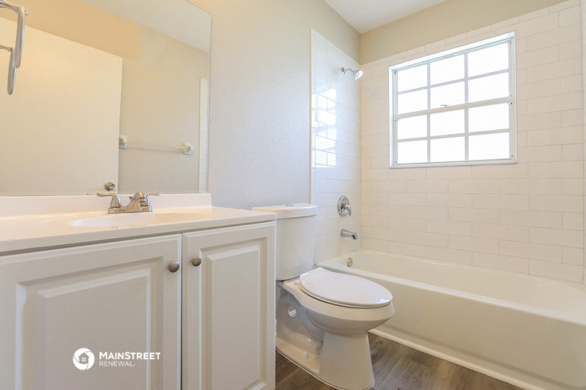 a bathroom with a toilet and a tub and a sink