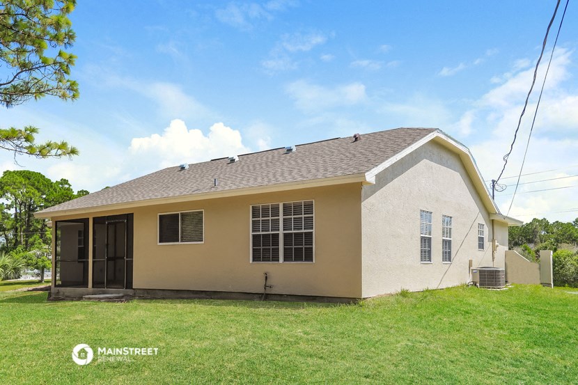 the front of a house with a green lawn and a blue sky