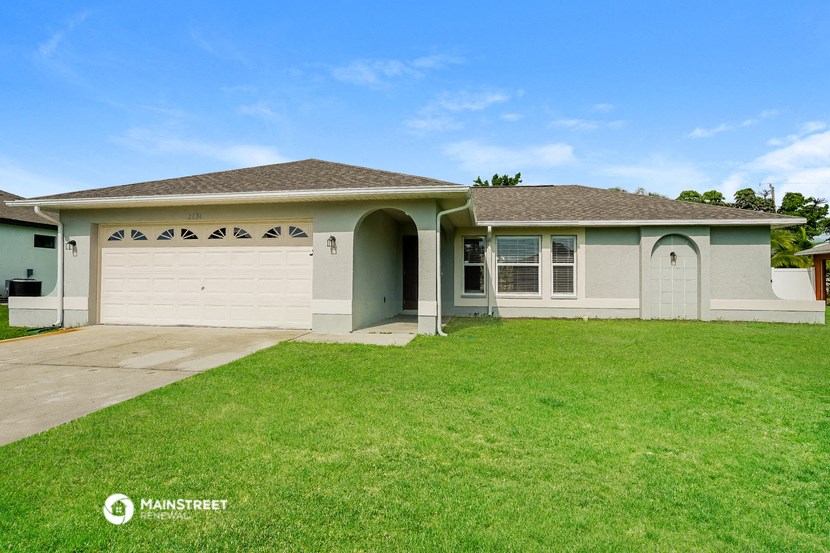 a white house with a garage and a green lawn