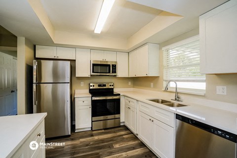 a kitchen with white cabinets and stainless steel appliances