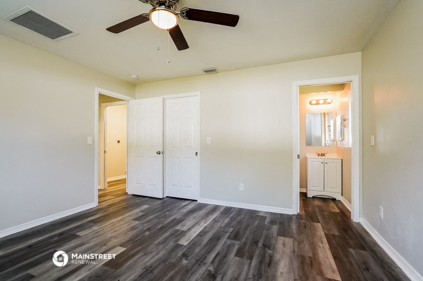 a living room with white walls and a ceiling fan