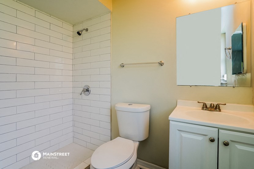 a bathroom with a toilet and a sink and a shower