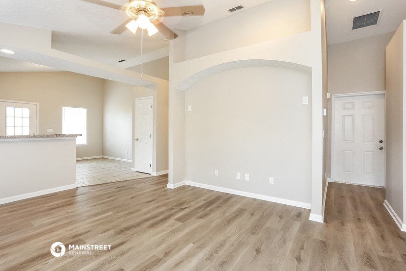 the living room and dining room of an empty house
