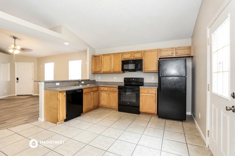 a kitchen with black appliances and wooden cabinets