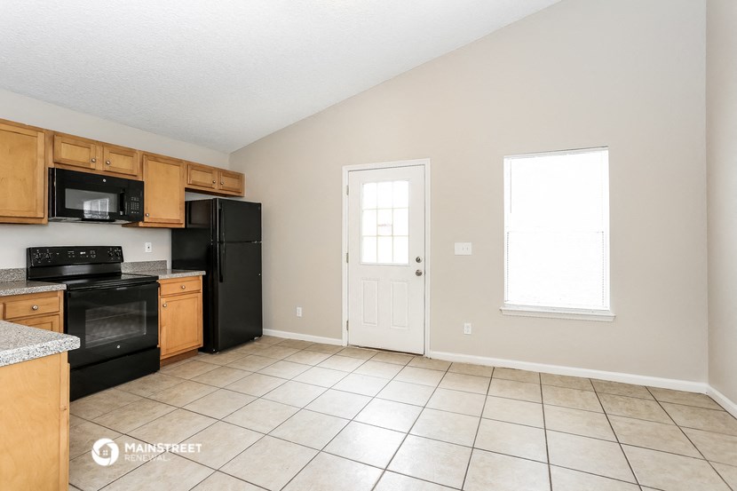 an empty kitchen with black appliances and tile flooring