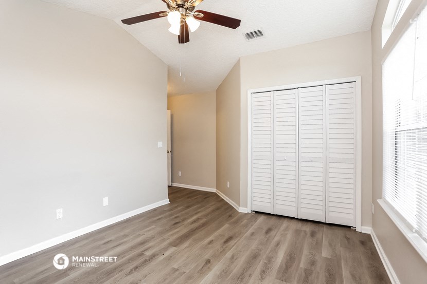 an empty living room with a large closet and a ceiling fan