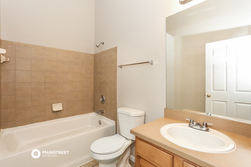 a bathroom with a toilet sink and tub and a mirror