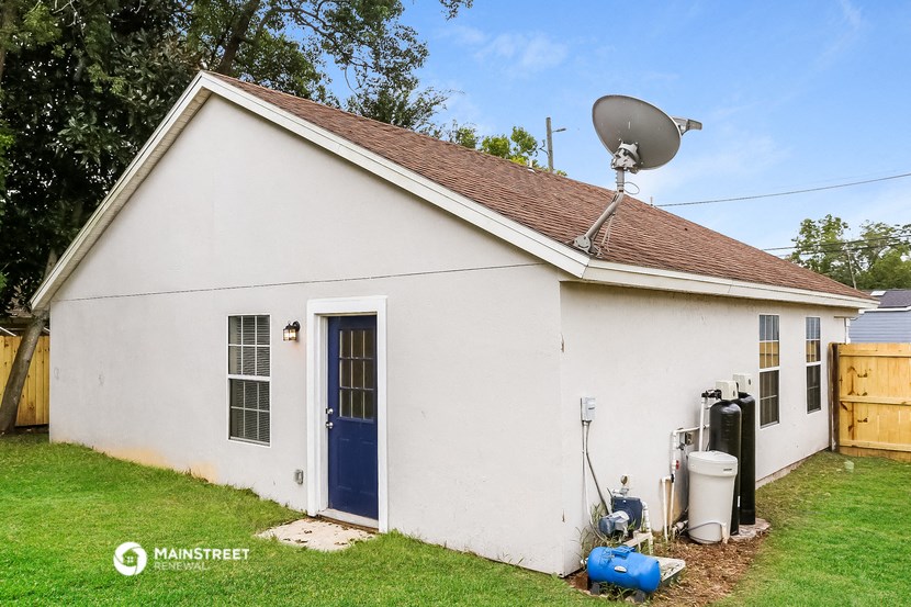 a white house with a blue door and a satellite dish on the roof