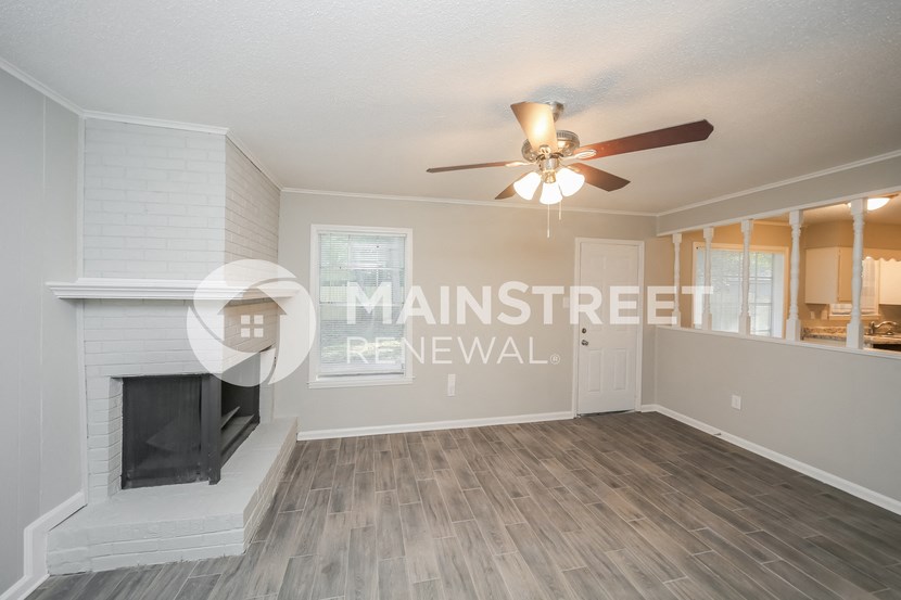 a living room with a fireplace and a ceiling fan