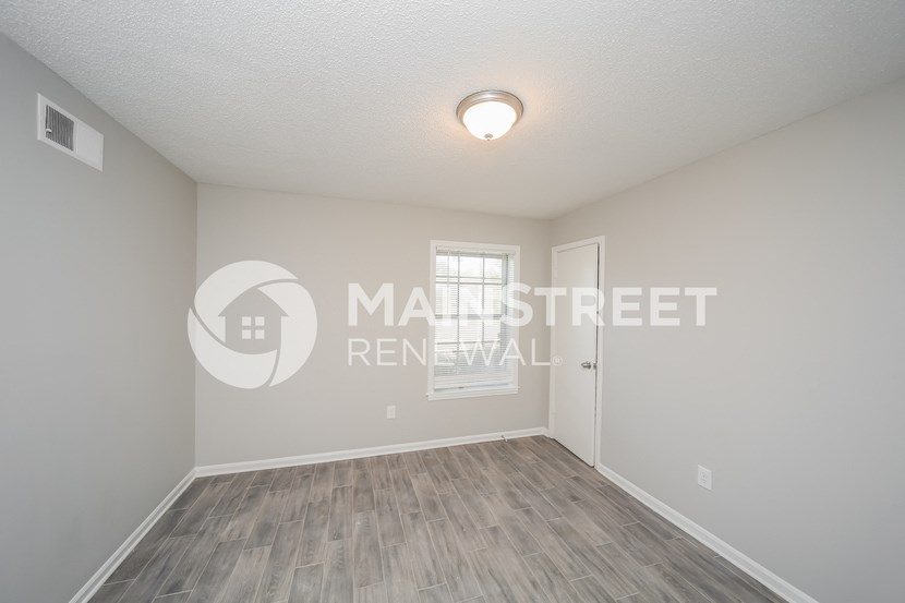 an empty living room with a window and a door