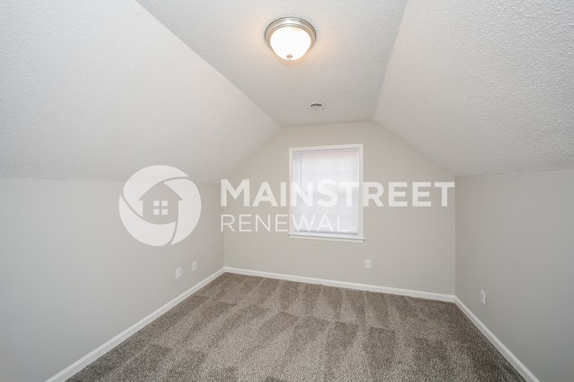 an empty room with carpet and a window