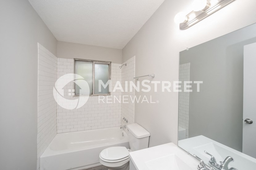a renovated bathroom with a sink toilet and shower