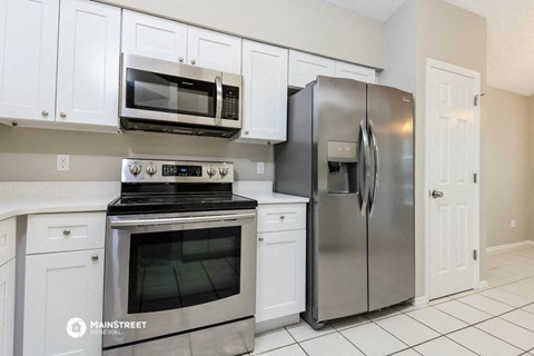 a kitchen with stainless steel appliances and white cabinets