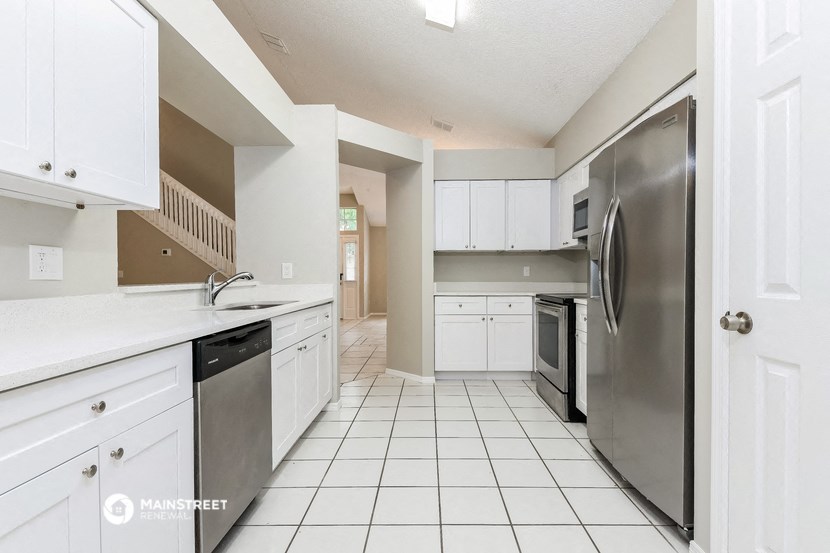 a large kitchen with white cabinets and stainless steel appliances