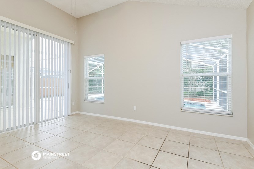 an empty living room with sliding glass doors to a patio