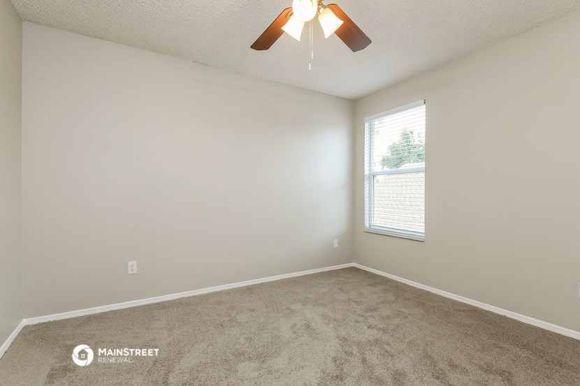 a bedroom with a ceiling fan and a window