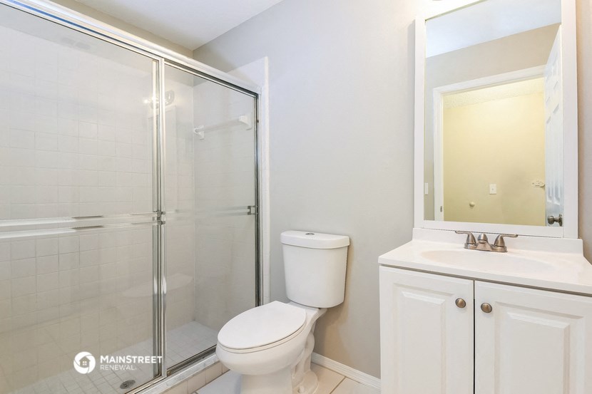 a white bathroom with a shower toilet and sink