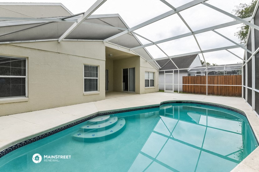 the pool is under an enclosure in the backyard of a house