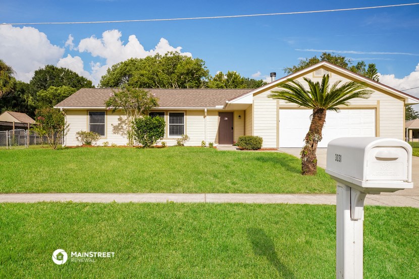 a yellow house with a palm tree in front of it