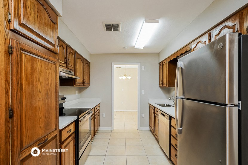 a kitchen with wooden cabinets and stainless steel appliances