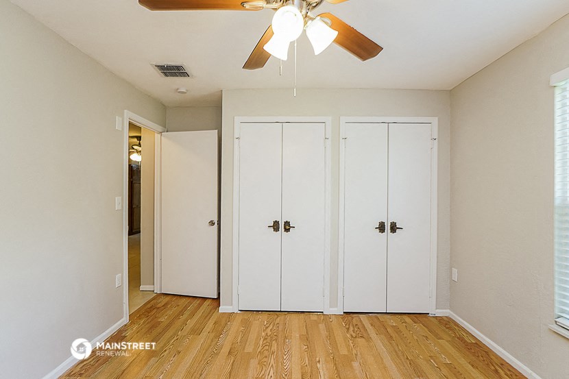 a bedroom with two closets and a ceiling fan