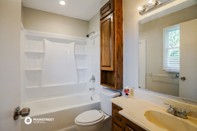 the master bathroom has a tub and a sink and a toilet