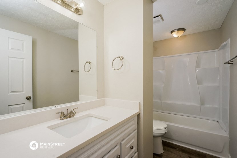 a bathroom with a sink and a shower and a toilet