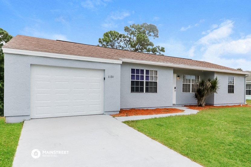 a white house with a lawn and a white garage door