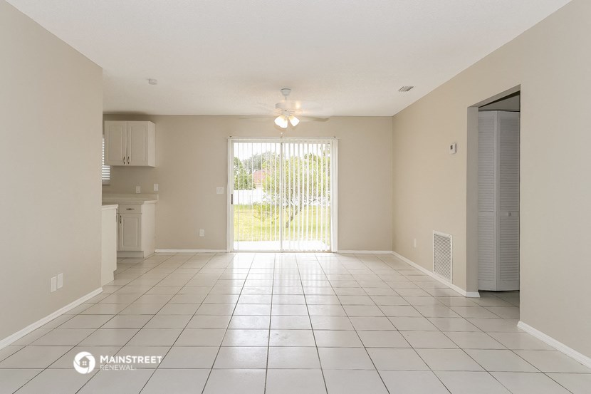 an empty living room with a sliding glass door to a patio