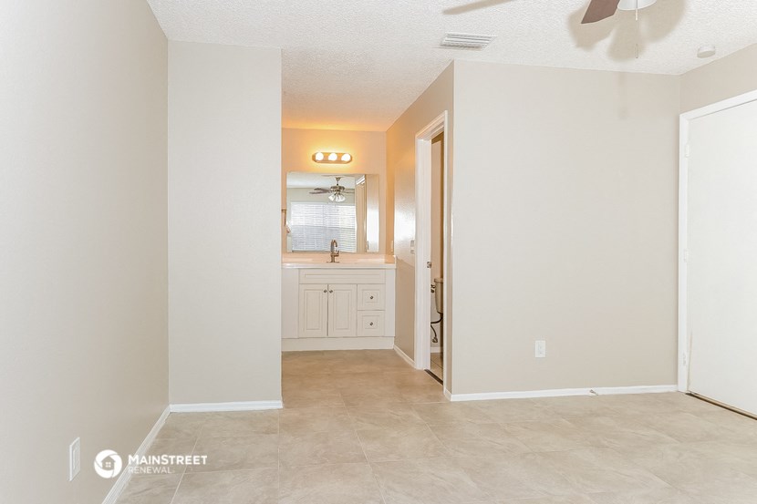 an empty room with a bathroom and a sink and a mirror