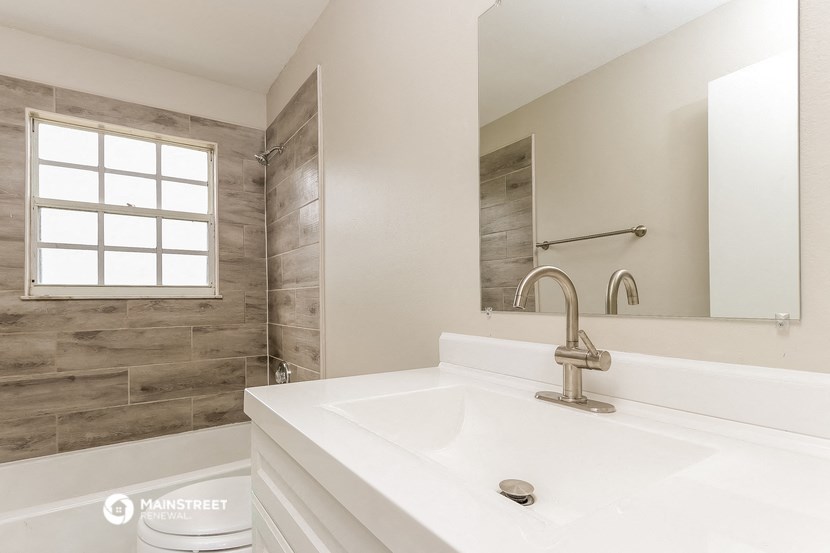 a bathroom with a sink and a shower and a mirror