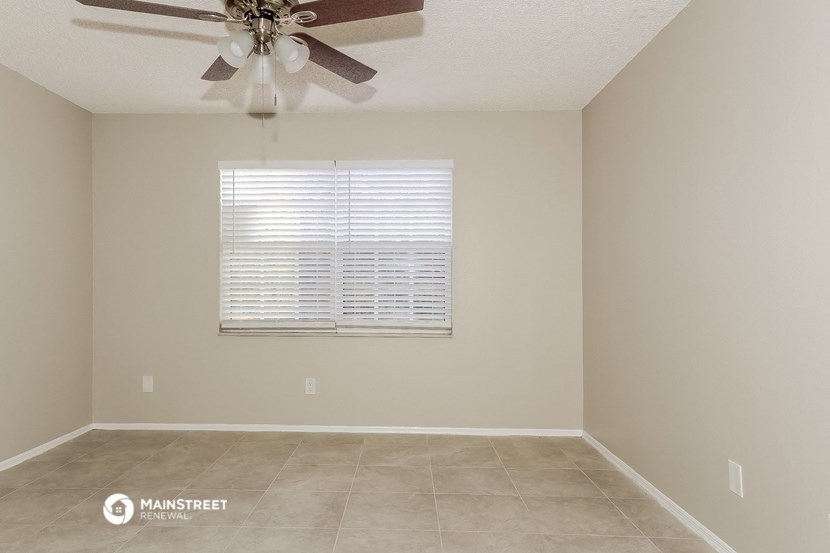 a living room with a ceiling fan and a window