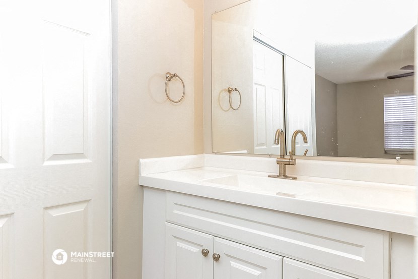 a white bathroom with a sink and a mirror