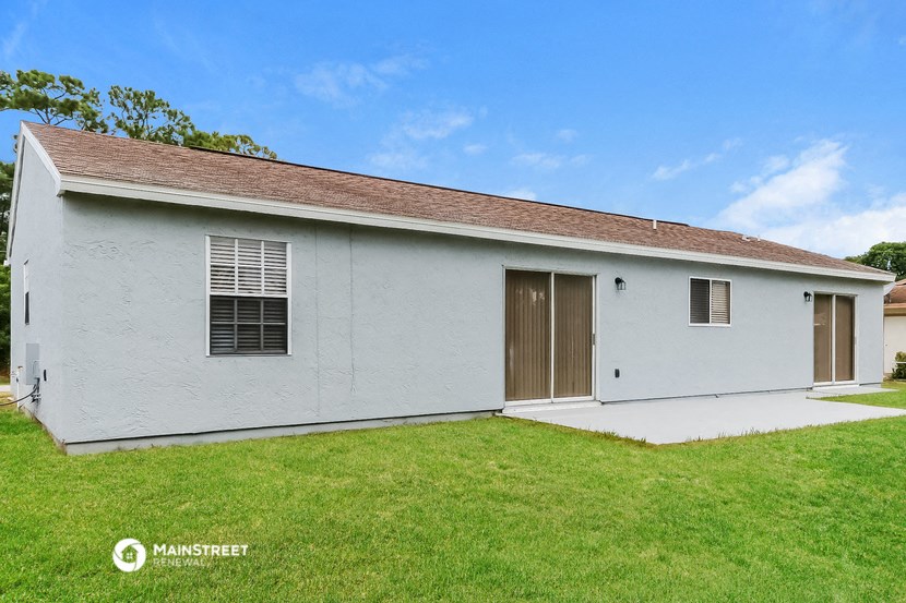 a small white building with a green lawn and a blue sky