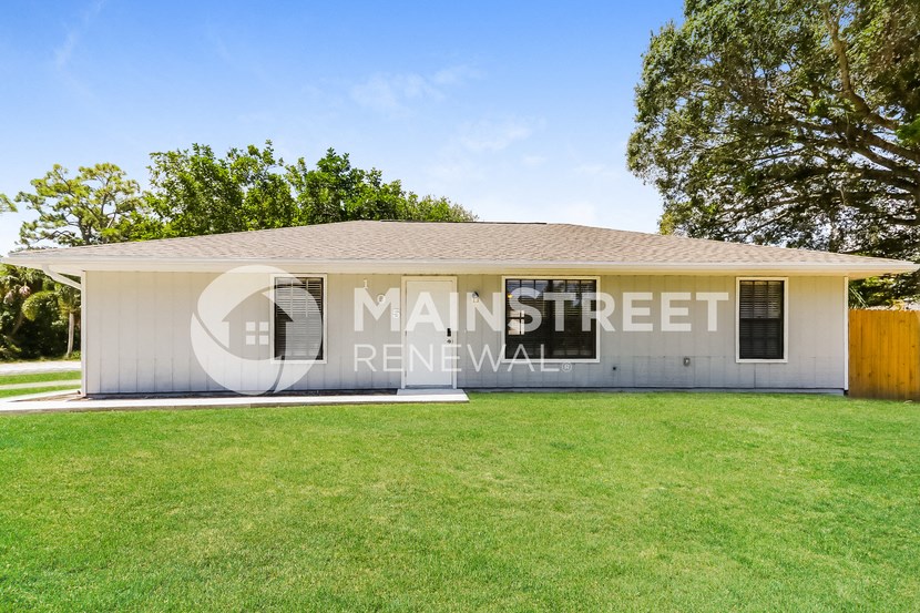 a small white building with a lawn in front of it