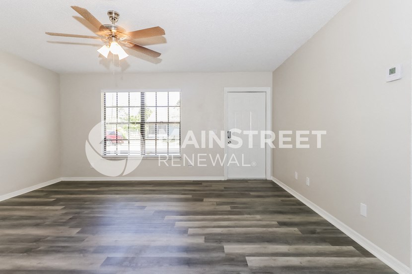 a living room with a ceiling fan and a window