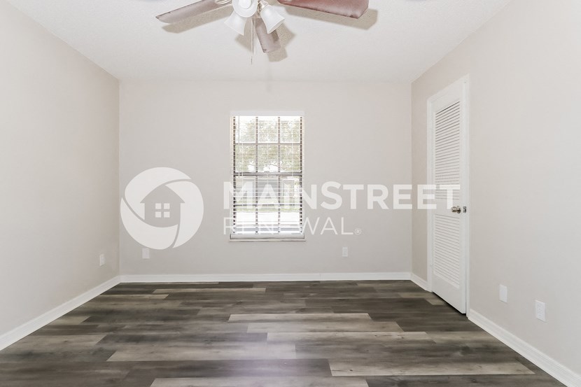 a living room with a ceiling fan and a window