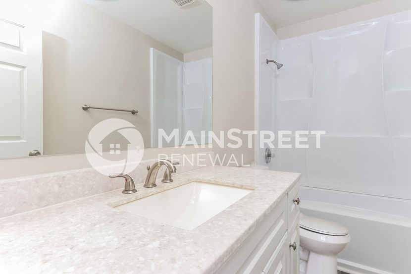 a white bathroom with a sink and a toilet