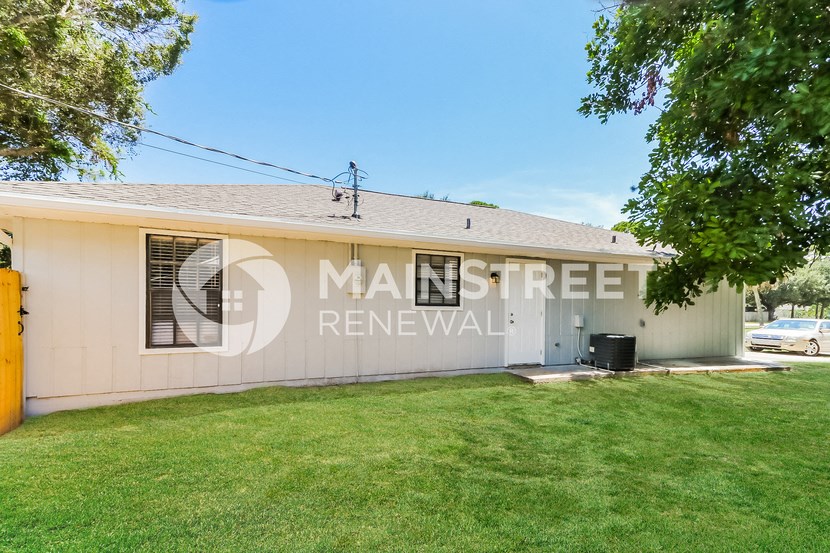 a house with a lawn and a car parked in front of it