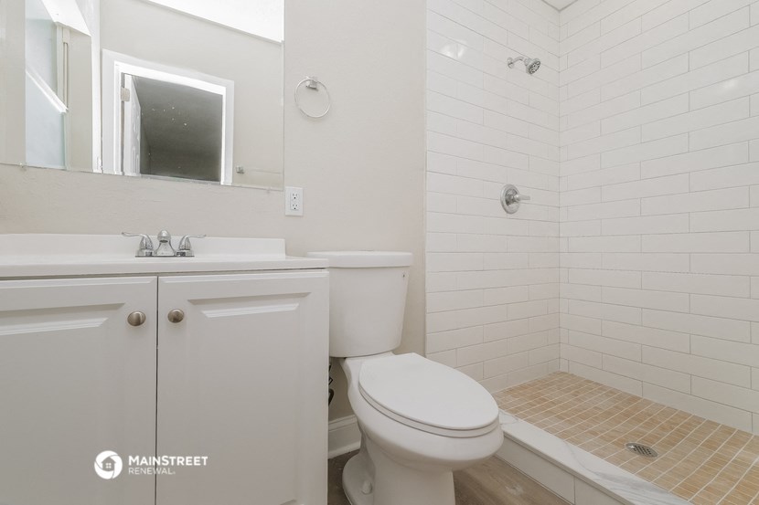 a white bathroom with a toilet and a sink