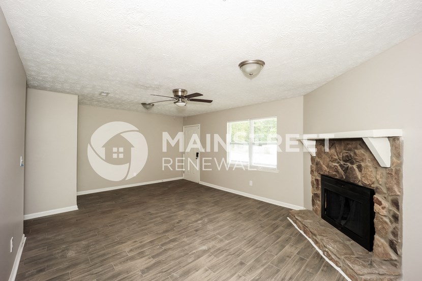 a living room with a fireplace and a wooden floor