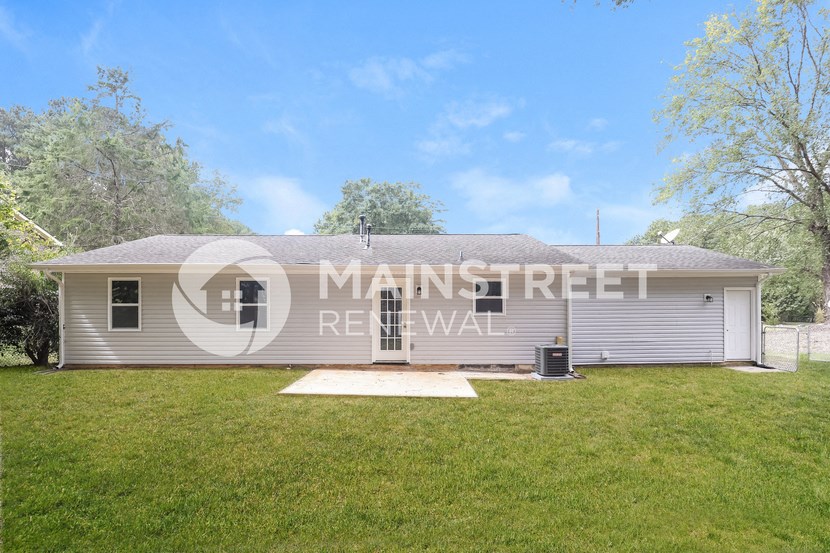 a small house with a grass yard in front of it