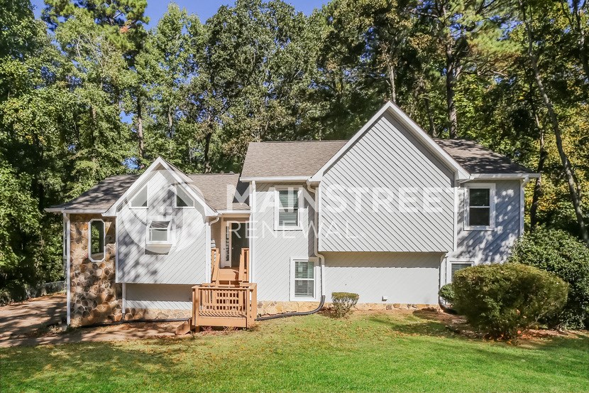 a small white house with a porch and a lawn